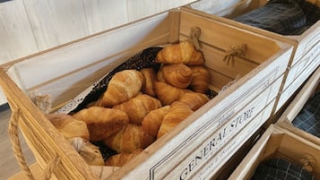 A wooden crate filled with croissants, labeled 'GENERAL STORE'.