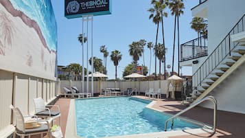 Alberca al aire libre, sombrillas en la alberca y camastros