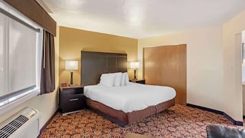 Habitación de hotel con cama, lámparas de noche, calefacción y alfombra estampada.