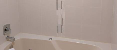 Een badkamer met een bad, een douchekop en een toilet.