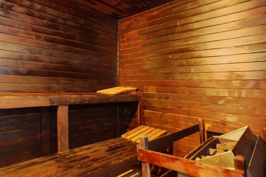 A sauna with wooden benches and a bench on the wall.