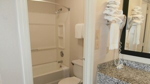 A bathroom with a shower, toilet, and a sink with a towel rack. - Americas Best Value Inn Blue Ridge (Blue Ridge)