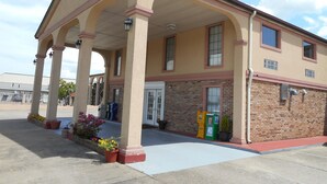 A building with a covered entrance, columns, and a brick facade. - Americas Best Value Inn Blue Ridge (Blue Ridge)