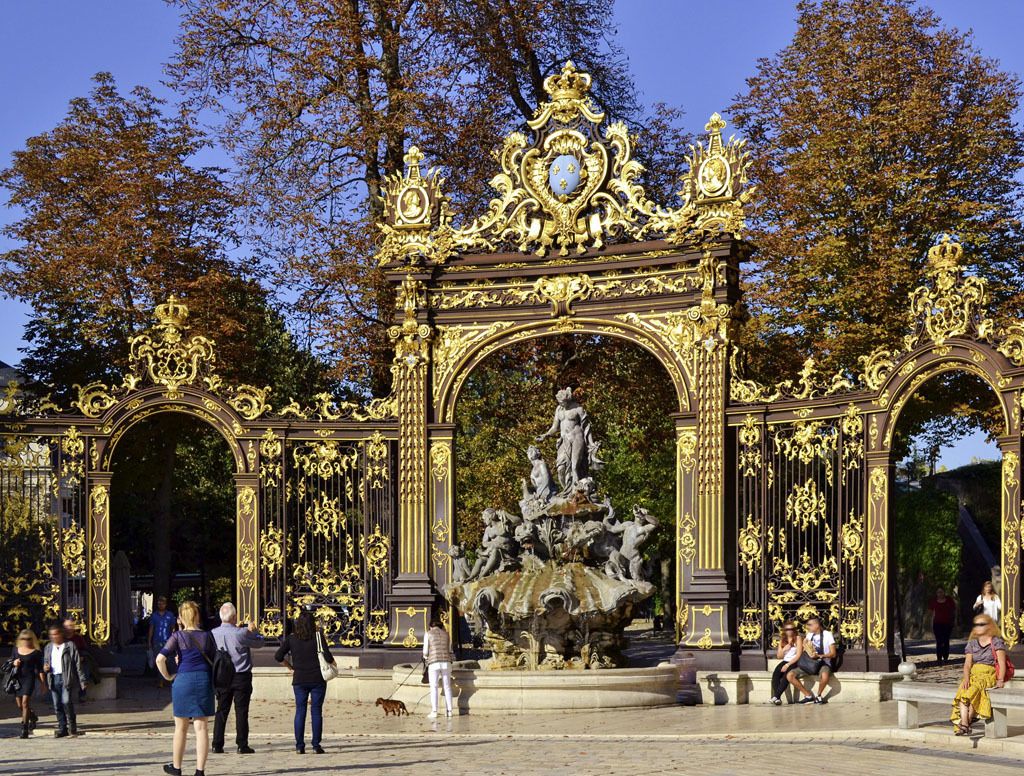 An ornate golden archway with a central fountain sculpture.