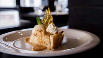 A dessert on a plate with a caramel sauce and a scoop of ice cream.
