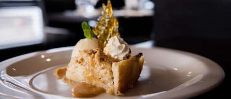 A dessert on a plate with a caramel sauce and a scoop of ice cream.