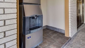 A compact, modern kitchenette with a built-in refrigerator and a water dispenser. - Econo Lodge Falfurrias Hwy 281 (Falfurrias)
