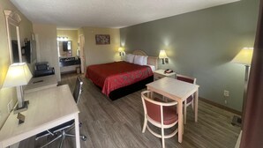 A hotel room with a bed, desk, chair, and a small table. - Econo Lodge Falfurrias Hwy 281 (Falfurrias)