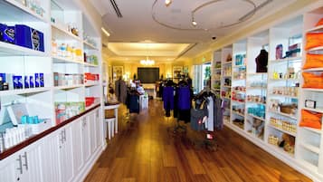 A store with wooden flooring, white shelving, and various products on display.