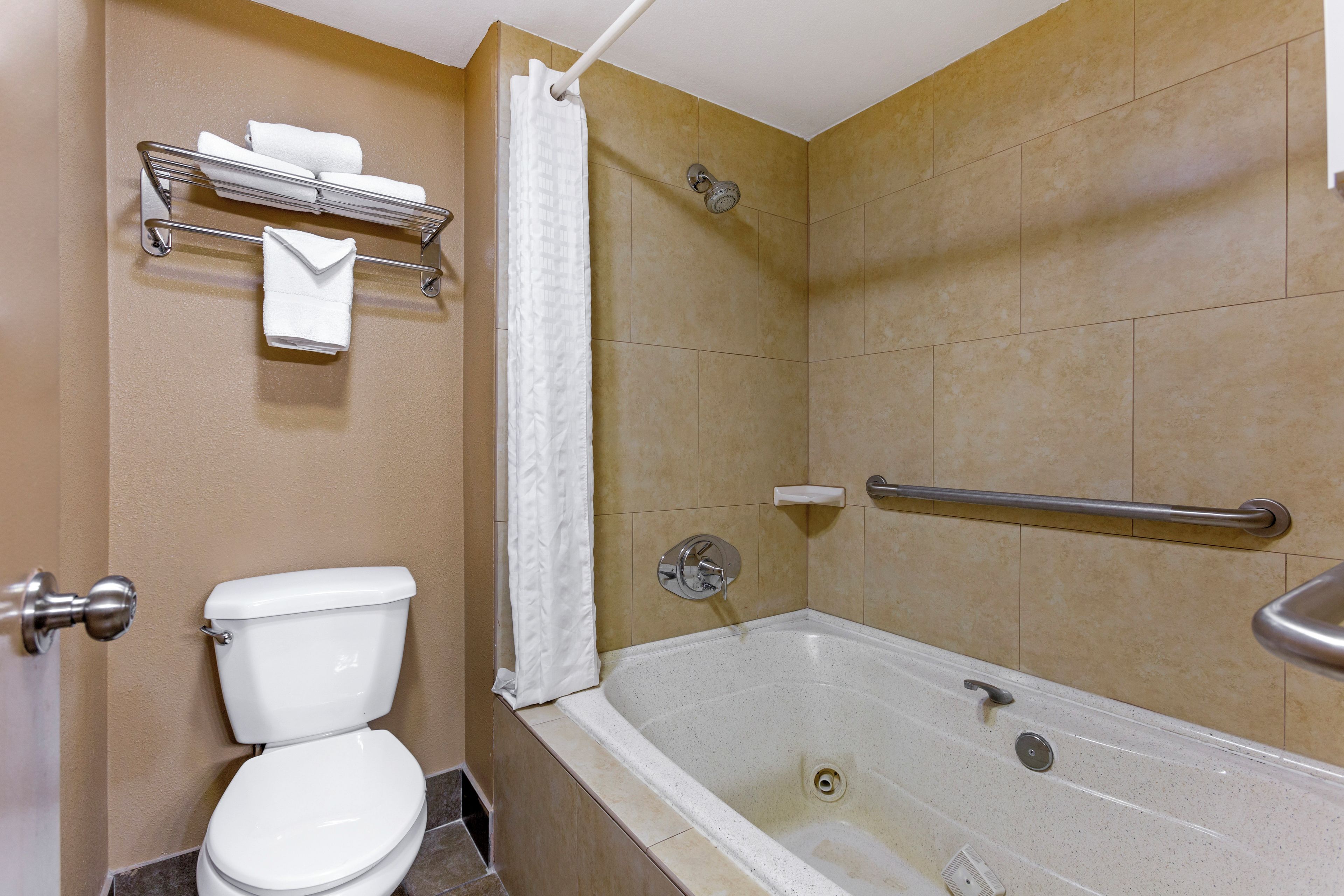 A bathroom with a toilet, a shower with a glass door, and a bathtub.