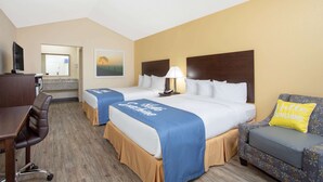 Una habitación de hotel con dos camas, un escritorio, una silla y un sofá.