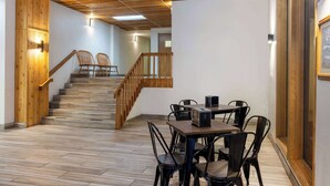 A wooden staircase leading to a dining area with a table and chairs.