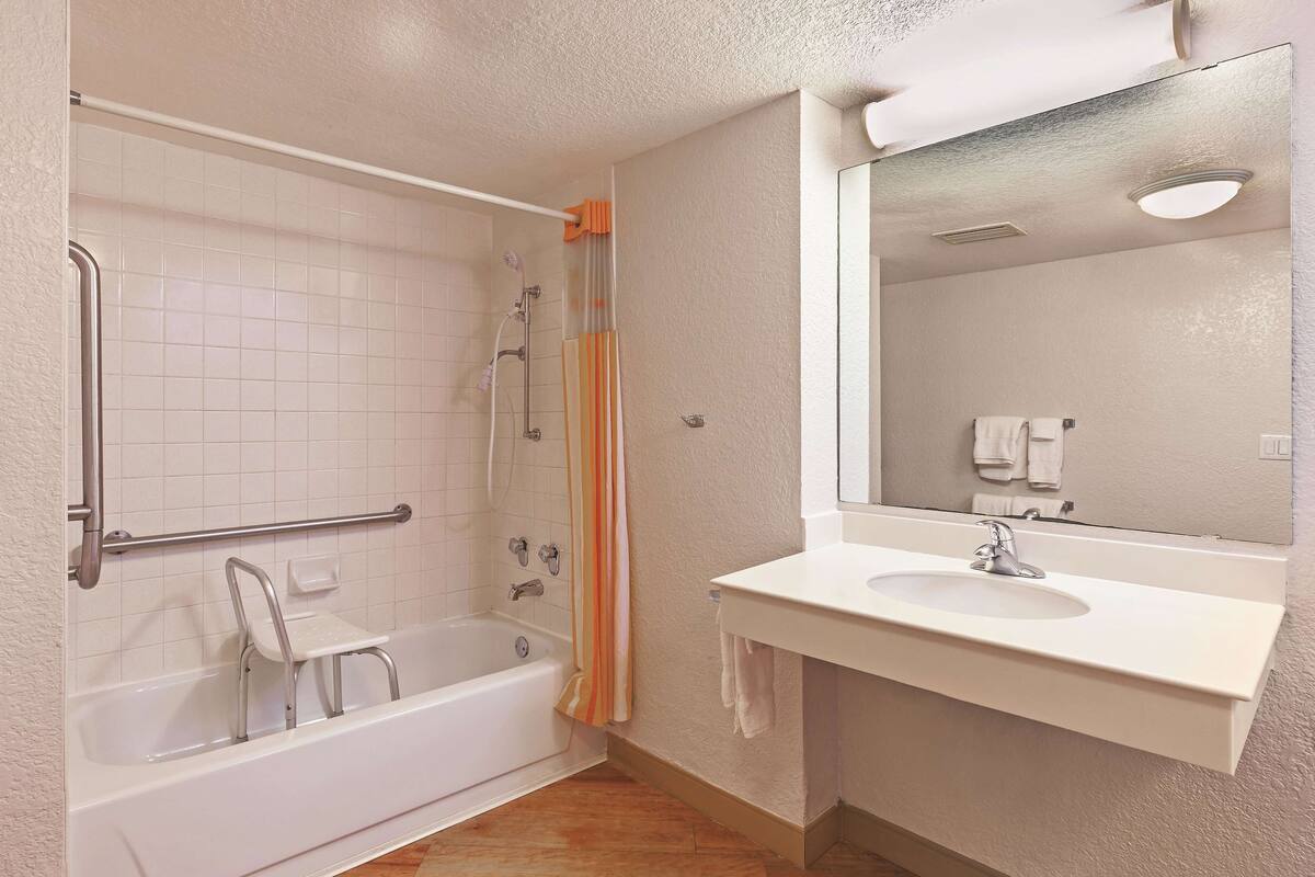 Un baño con bañera, ducha y lavamanos.