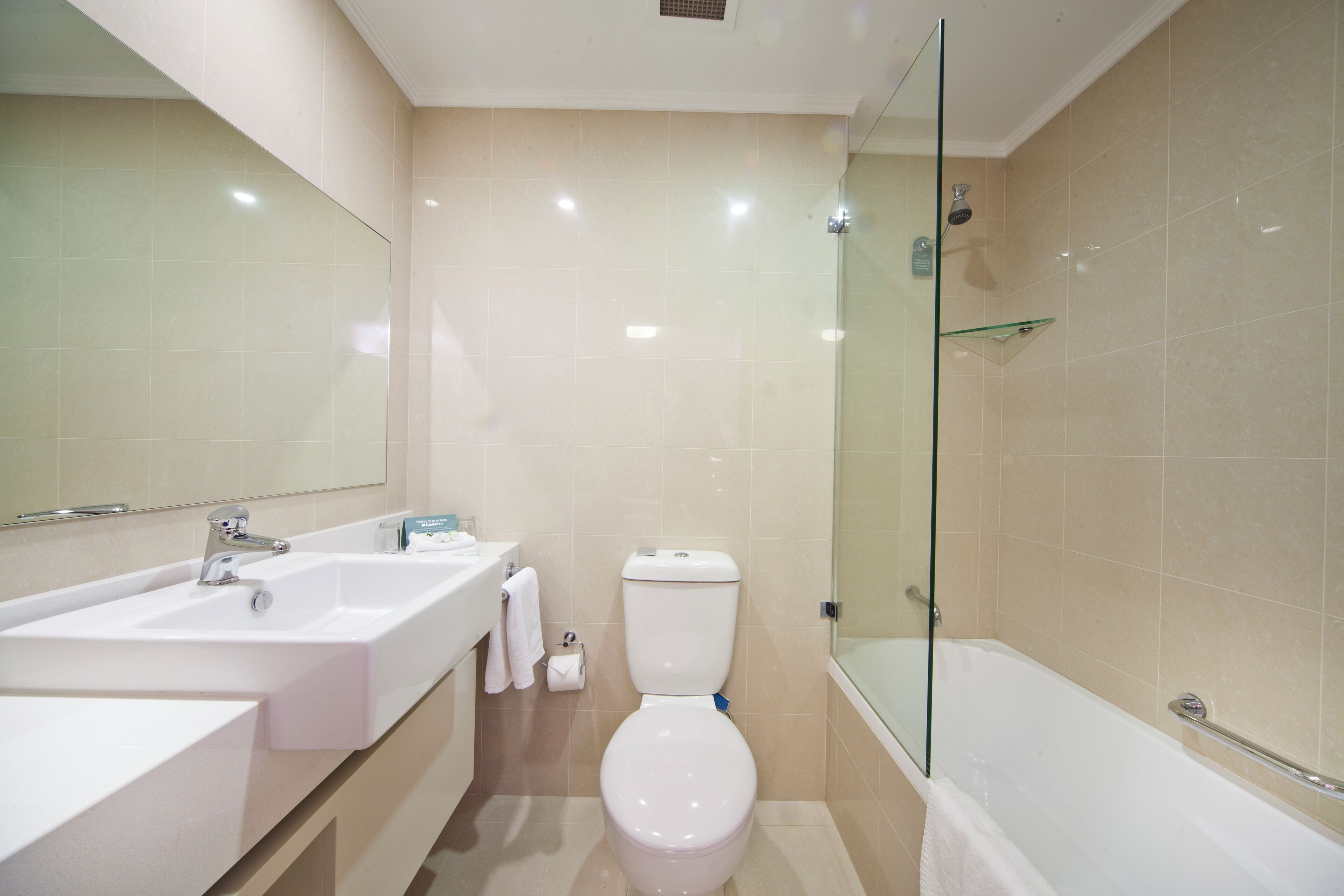 Un baño moderno con lavamanos, inodoro y bañera blancos.