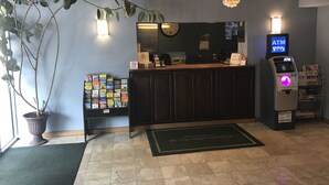 A reception area with a counter, a clock, an ATM, and a welcome mat. - Americas Best Value Inn Pottstown (Pottstown)