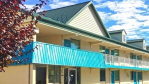 A motel with a two-story structure, a balcony, and a sign advertising amenities like a non-smoking room, free continental breakfast, and in-room microwaves. - Americas Best Value Inn Pottstown (Pottstown)