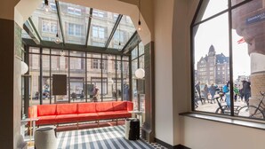 Ein modernes Interieur mit einem großen Fenster, einer roten Bank und einem gemusterten Boden.