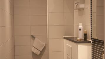 A modern bathroom with a shower, toilet, and sink.