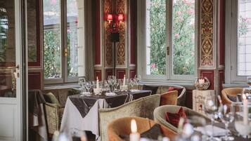 Un restaurante con mesas dispuestas para comer, destacando un centro de mesa con velas y elegantes mantelería.