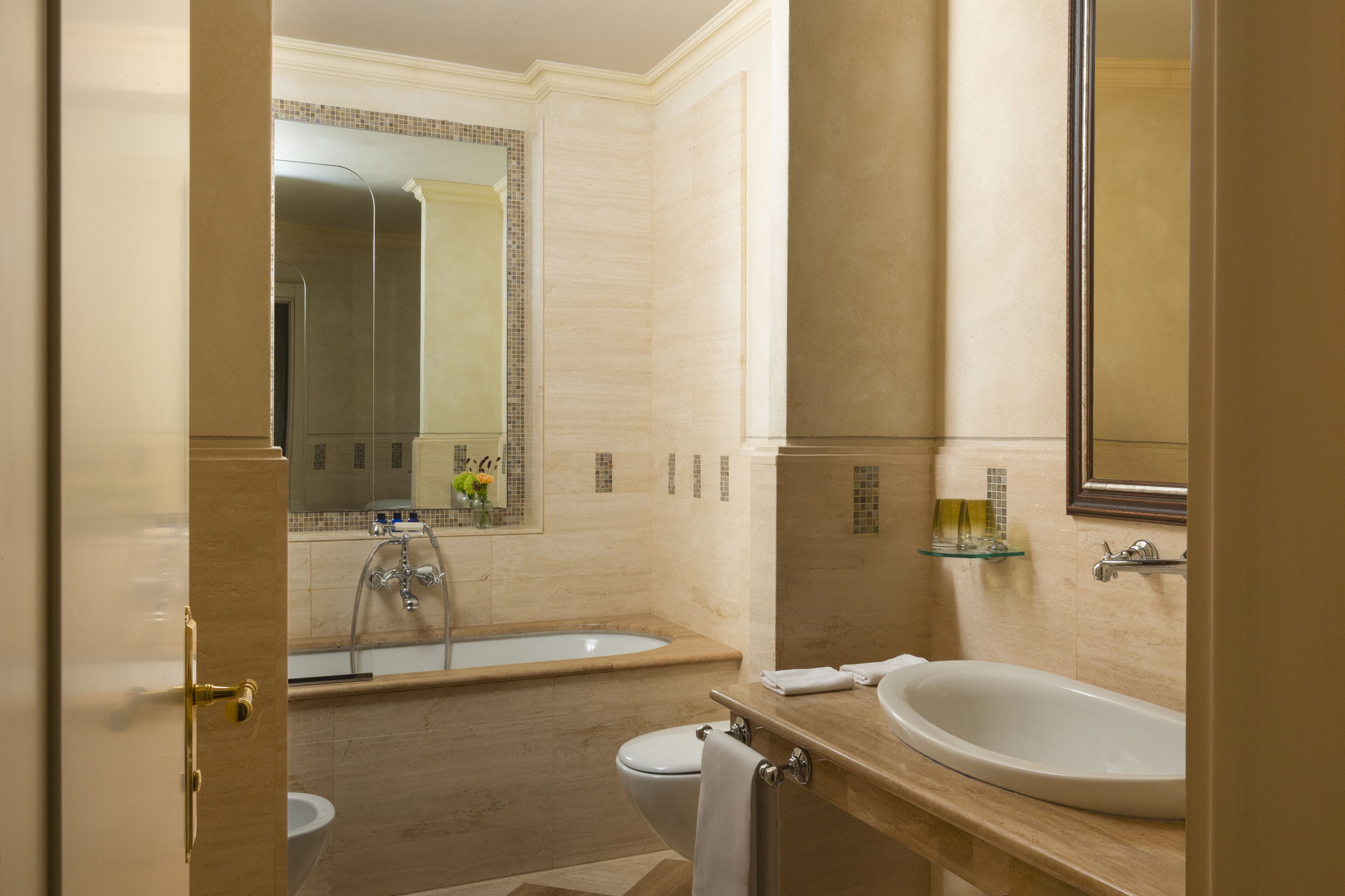 A bathroom with a bathtub, a toilet, a sink, and a mirror.