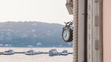 Eine Uhr mit Blick auf Boote auf dem Wasser und eine hügelige Landschaft im Hintergrund.