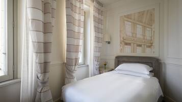 Una cama bien hecha en una habitación de hotel con vista a un edificio a través de una ventana.
