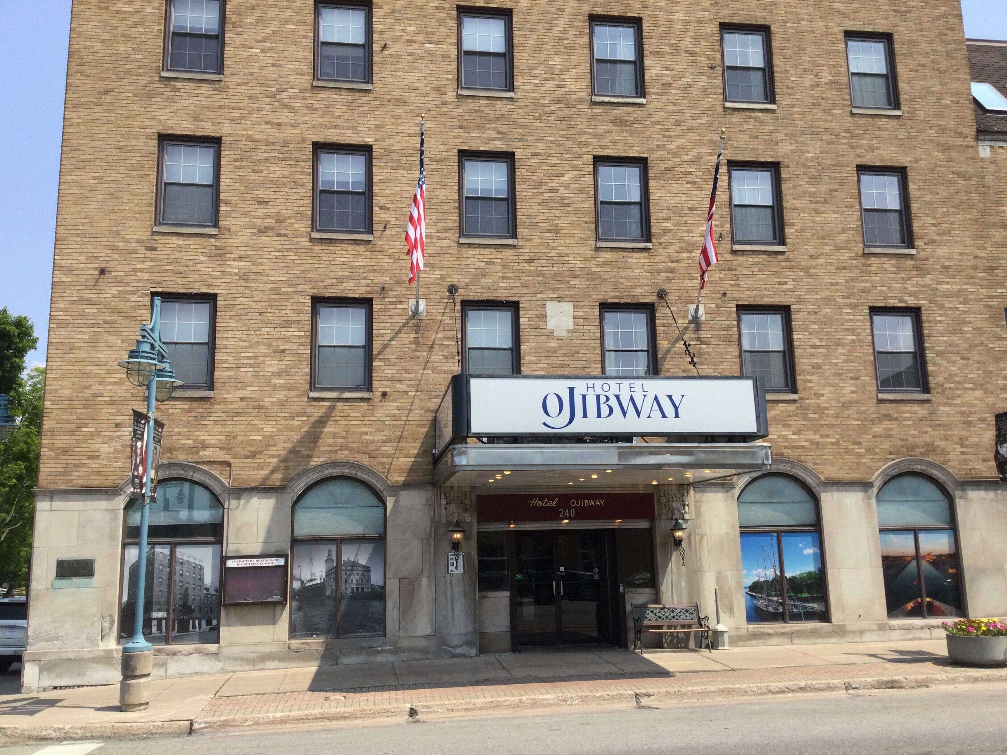 A hotel with a brick facade, multiple windows, and two American flags.