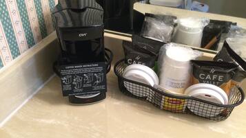 Een koffiezetapparaat en koffiecups op een aanrecht.