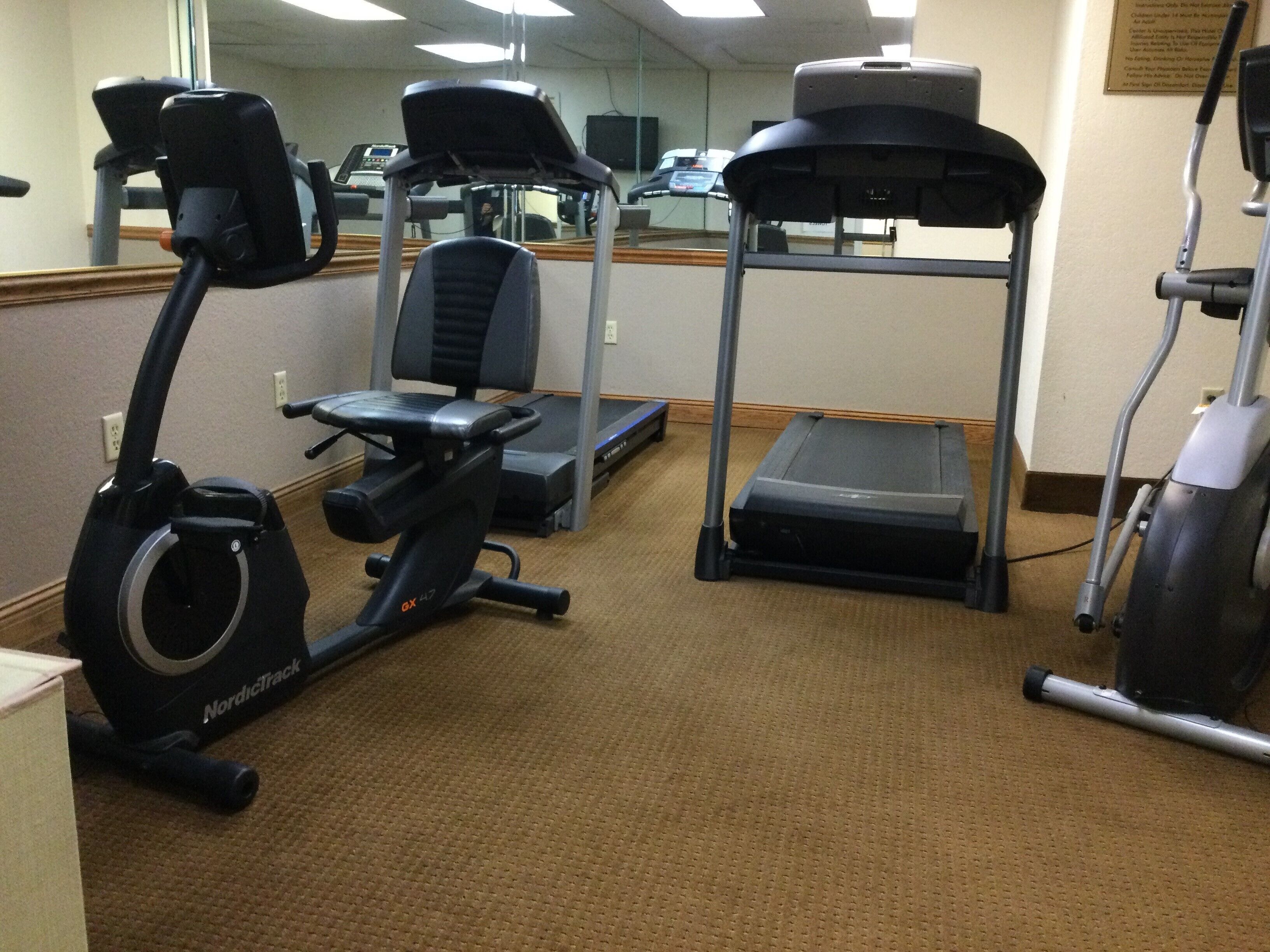 A gym with treadmills, an elliptical, and a stair climber.