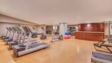 Ein Fitnessstudio mit mehreren Laufbändern, Crosstrainern und weiteren Trainingsgeräten.