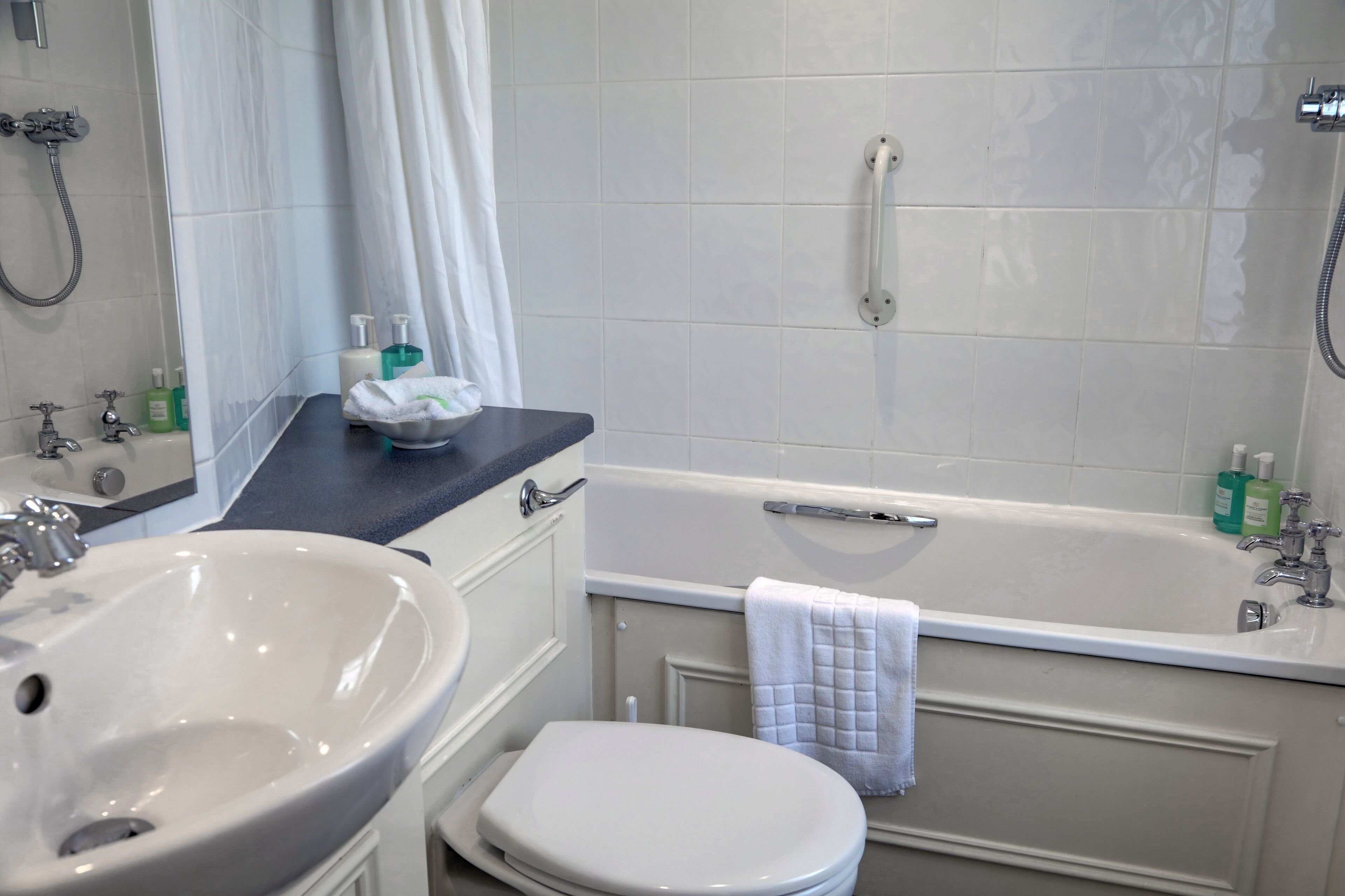 A bathroom with a sink, toilet, and bathtub.