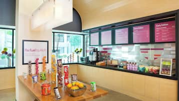 A breakfast bar with a variety of food items and a menu board displaying breakfast options.