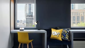 Un espace de bureau moderne comprenant un bureau, une chaise et un canapé avec un coussin.