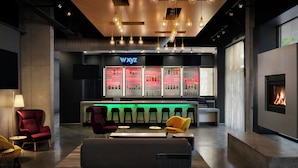 Un espace bar moderne avec un néon, des tabourets de bar et une cheminée.