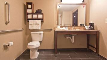 Une salle de bain équipée de toilettes, d’un lavabo, d’un miroir et d’un porte-serviettes.