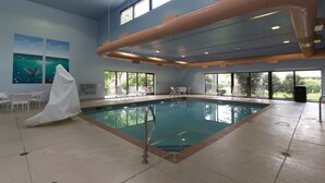 An indoor swimming pool with clear blue water, a covered lifeguard chair, and a no diving sign. - Hampton Inn Columbus-South (Grove City)