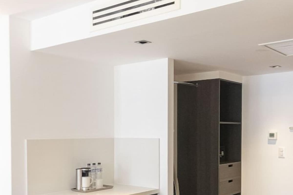 A compact kitchenette with a built-in refrigerator, a coffee machine, and a microwave.