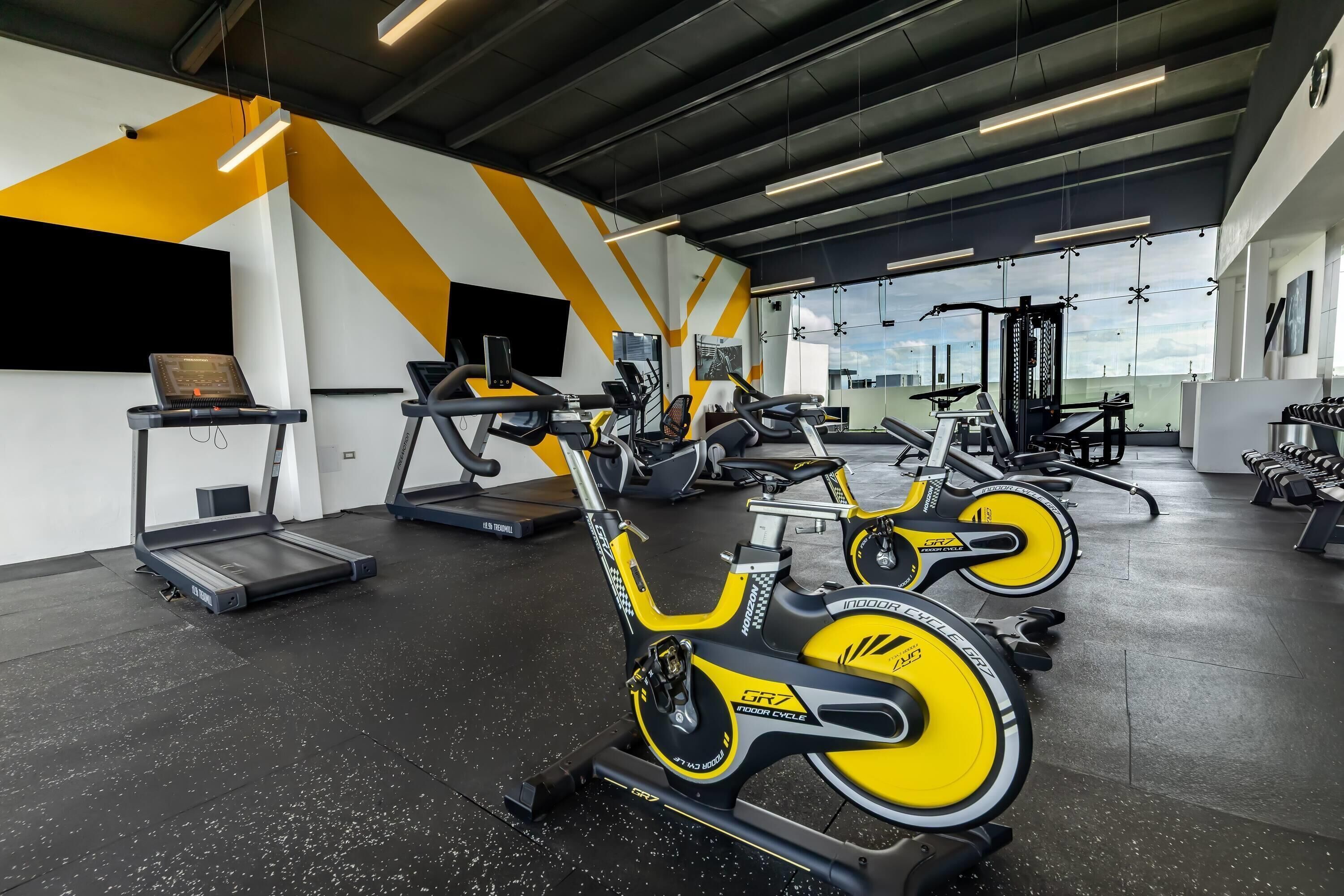 A gym with stationary bikes, treadmills, and weight machines.