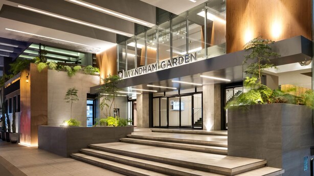 A modern building entrance with a sign reading "WYNDHAM GARDEN".