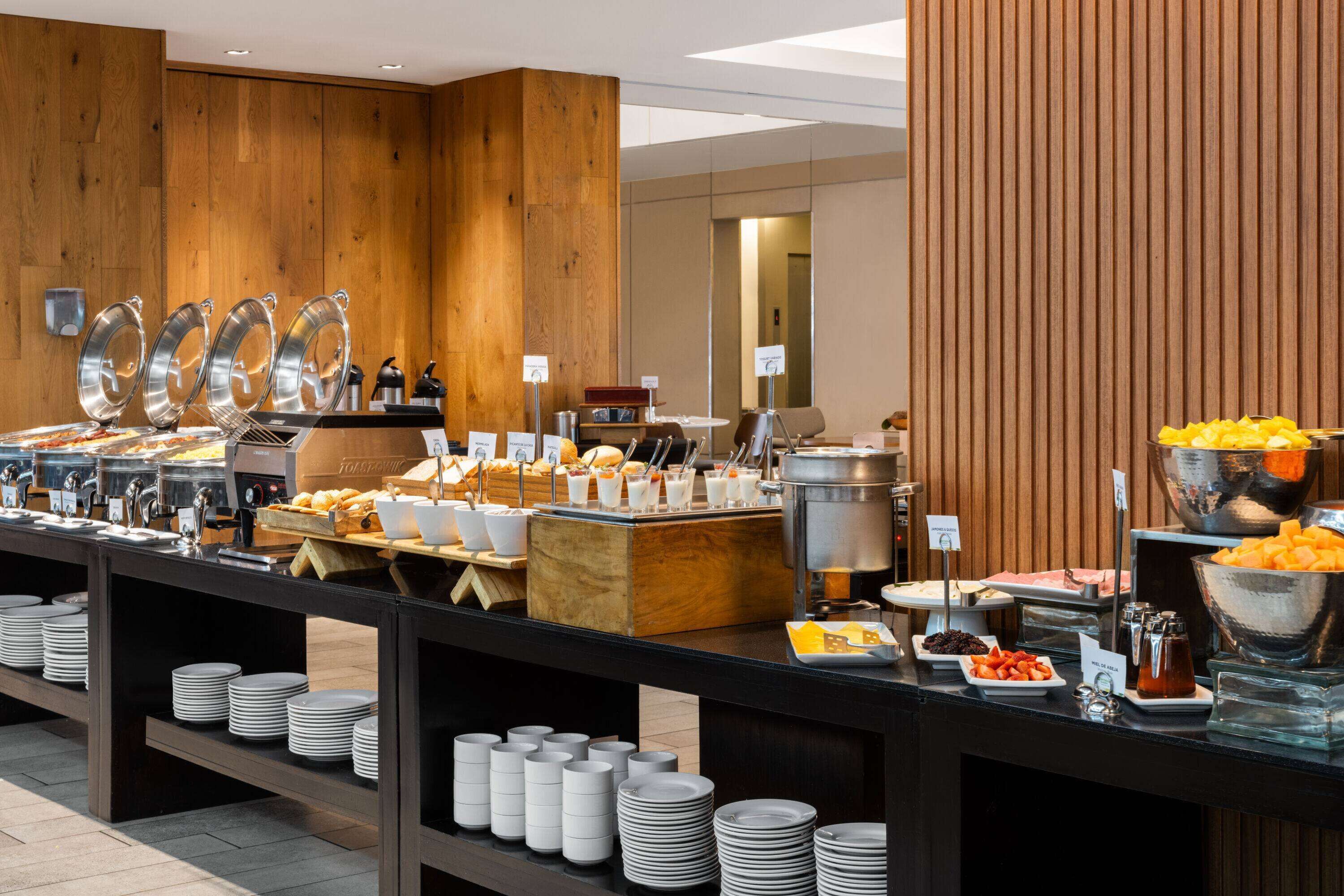Una mesa de buffet con diversos alimentos y utensilios.