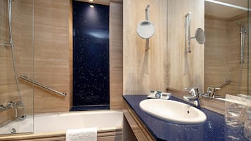 A modern bathroom with a bathtub, a sink, and a shower area.