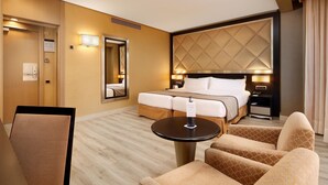 Une chambre d’hôtel comprenant un lit, un bureau, une chaise, une table et un miroir.