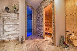 A spa area with a wooden sauna, a stone wall, and a small Buddha statue. - Radisson Blu Hotel, Halle-Merseburg (Merseburg)