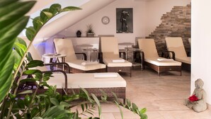 A modern lounge area with wicker furniture, a stone staircase, and a Buddha statue. - Radisson Blu Hotel, Halle-Merseburg (Merseburg)