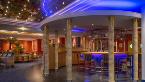 A bar area with a curved layout, marble columns, and a blue-lit bar counter. - Radisson Blu Hotel, Halle-Merseburg (Merseburg)