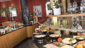 A buffet setup with various food items and a decorative mirror. - Radisson Blu Hotel, Halle-Merseburg (Merseburg)