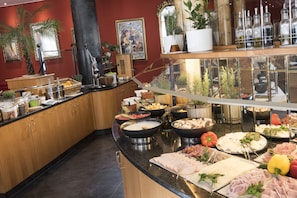 Enjoy a sumptuous spread of meats, cheeses, and vegetables at our buffet.