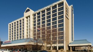 Un hotel de varios pisos con un letrero destacado que dice 'Pearl Tree Inn by O'Dell'.