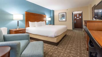 Quarto de hotel com uma cama grande, duas mesas de cabeceira com luminárias, uma escrivaninha e um armário.