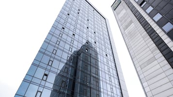Un moderno edificio de hotel con fachada de vidrio y un letrero que dice 'Quality Hotel Panorama'.